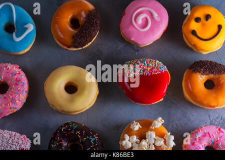 Süße Krapfen am grauen Stein Hintergrund Stockfoto