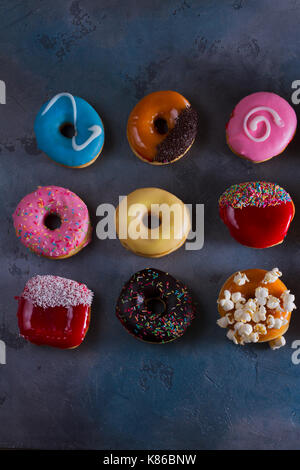 Süße Krapfen am grauen Stein Hintergrund Stockfoto