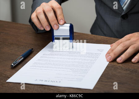 Nahaufnahme der Geschäftsmann Stanzen Dokument am Schreibtisch im Büro Stockfoto