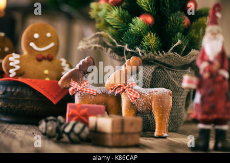 Weihnachtsdekoration. Gingerbread Cookies. Weihnachtsmann und Rentier mit Weihnachtsbaum, Geschenke und Lebkuchen Mann. Stockfoto