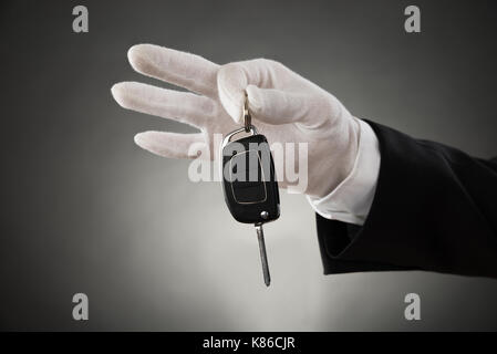 Nahaufnahme der Kellner Hände In weißen Handschuhen Auto-Taste Gedrückt halten Stockfoto