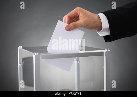 Nahaufnahme der Geschäftsmann, Hände, Stimmzettel in Feld am Schreibtisch Stockfoto