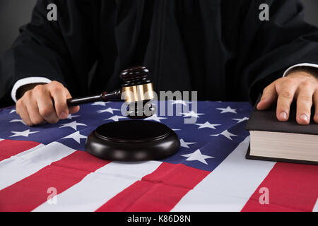 Close-up des Richters Hände mit Hammer und die amerikanische Flagge auf dem Schreibtisch Stockfoto