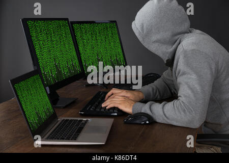 Hacker Schreiben auf Computern mit binären Code am Schreibtisch Stockfoto