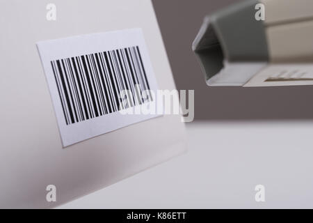 Nahaufnahme der Person Hände über Barcode Scanner einen Barcode auf einer Box zu Scannen Stockfoto