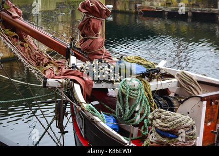 Ein Boot am Hafen aufgetürmt und mit Seilen Stockfoto