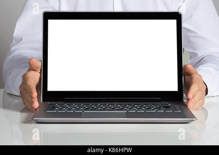 Mittelteil der Geschäftsmann, Laptop mit leerer Bildschirm am Schreibtisch Stockfoto