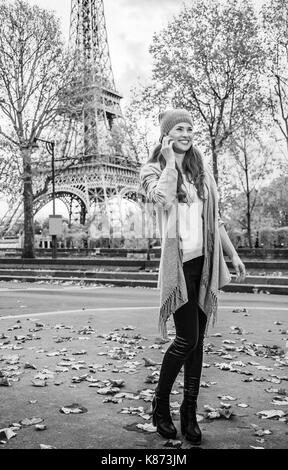 Herbst Kurzurlaube in Paris. In voller Länge Portrait von glückliche junge Frau in Paris, Frankreich mit dem Handy telefonieren Stockfoto