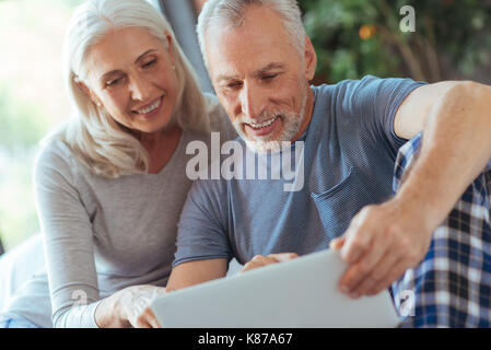 Freundliche nette im Alter von Paar mit Laptop Stockfoto