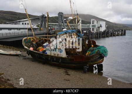 Angeln Boot Schiff bei Ebbe am Strand mit Pier und das Meer im Hintergrund bei Ullapool im westlichen Schottland Großbritannien Stockfoto