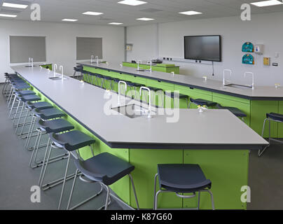 Wissenschaftslabor in einer neuen Londoner Sekundarschule. Zeigt Werkbänke mit Waschbecken und Gashahnen, Hocker und Lehrbereich.leer, keine Schüler. Stockfoto
