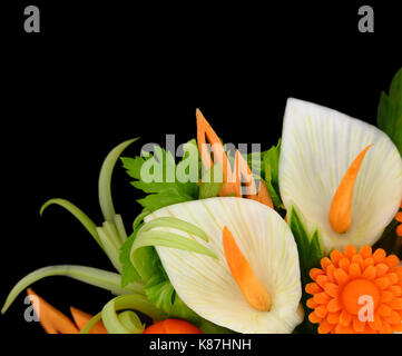 Blumen geschnitzt aus Früchten und Gemüse auf schwarzem Hintergrund Stockfoto