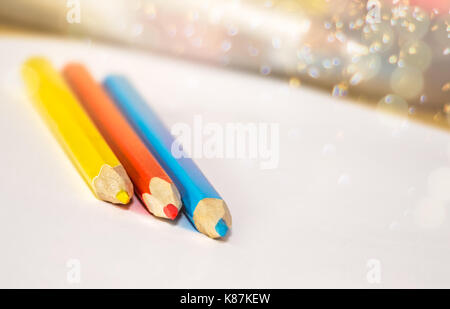 Rot, Gelb und Blau Buntstifte und weißen Blatt Papier auf dem Schreibtisch Stockfoto