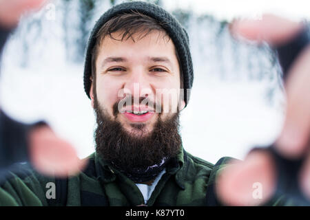 Mann unter selfie auf verschneiten Berg in der Nähe von Bärtigen Stockfoto