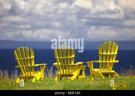 Drei Liegestühlen sitzen entlang der Küstenlinie in Nova Scotia, Atlantic Canada's provnices. Stockfoto