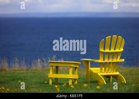 Drei Liegestühlen sitzen entlang der Küstenlinie in Nova Scotia, Atlantic Canada's provnices. Stockfoto