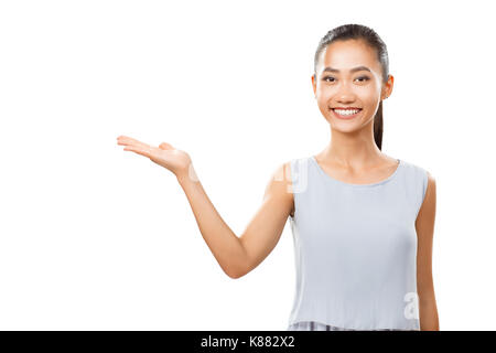 Studio Portrait von Asiatischen fröhliche Frau mit Öffnen Sie Palm angezeigt oder Präsentation abstrakten Produkt. Junge weibliche Modell glücklich lächelnde und Kamera. Stockfoto