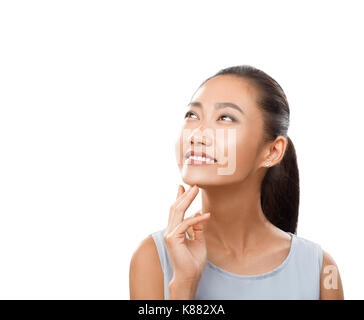 Portrait von asiatische Frau mit einem Lächeln bis nachdenklich. Happy girl Close-up mit dem Finger in die Nähe von Kinn und mit leicht ihren Kopf nach hinten abgelenkt. Stockfoto