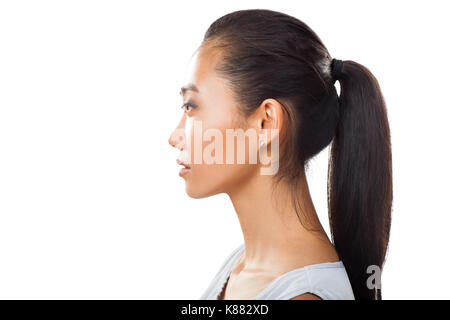 Closeup Portrait von Asiatische junge Frau im Profil mit Pferdeschwanz. Studio Foto hübsches Mädchen mit Gegerbten frische Haut und dunklen Haaren für verschiedene Beauty- und Stockfoto