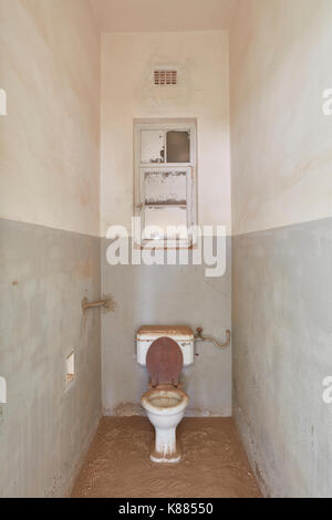 Ein Blick auf einer Toilette in einem verlassenen baufälligen Gebäude voller Sand. Stockfoto