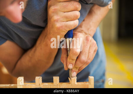 Der Mann bei der Arbeit ein Boot - Workshop in der Builder, gemeinsam zwei Stücke Holz. Stockfoto