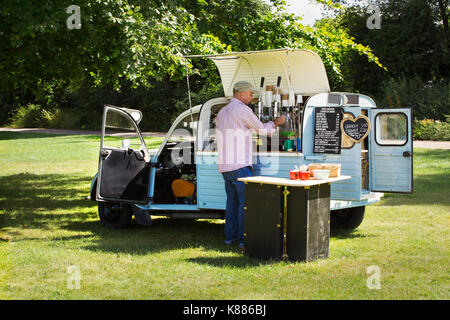 Der bärtige Mann mit Schürze ständigen von Blue mobile Coffeeshop, Kaffee machen. Geschäftsinhaber. Stockfoto