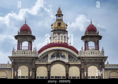 Mysore, Indien - 27. Oktober 2013: Nahaufnahme der vorderen Eingang mit kastanienbraunen Kuppeln nach Mysore Palast mit dem zentralen Turm mit goldenen Kuppeln oben spannen Stockfoto