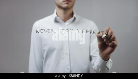 Nie aufhören zu lernen, Mann schreiben auf Glas Stockfoto