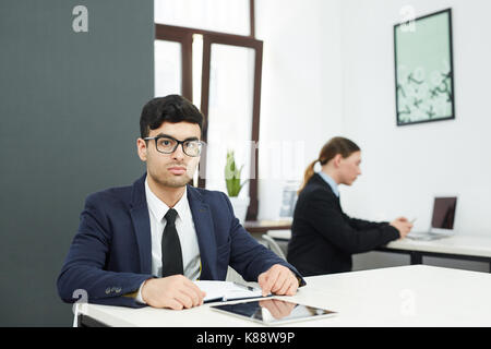 Junge schwere Geschäftsmann mit Notebook und Tablet sitzen, Schreibtisch Stockfoto