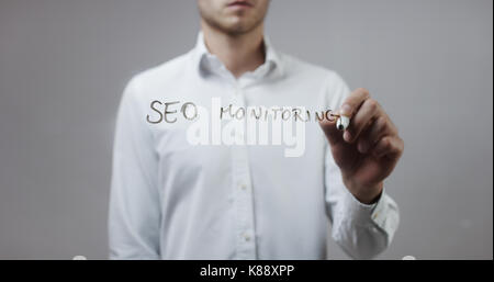 Seo Monitoring, Mann schreiben auf Glas Stockfoto