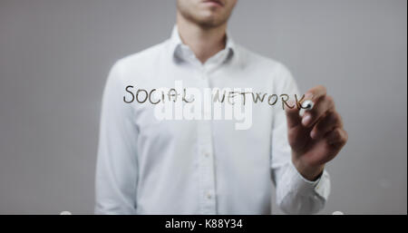 Soziales Netzwerk, Mann schreiben auf Glas Stockfoto