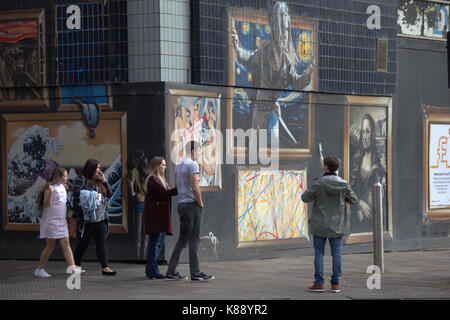 Touristen spielen und nehmen selfies auf der Vorderseite der Straße Wandmalereien zieren das Gebäude om Argyle Street Glasgow Stockfoto