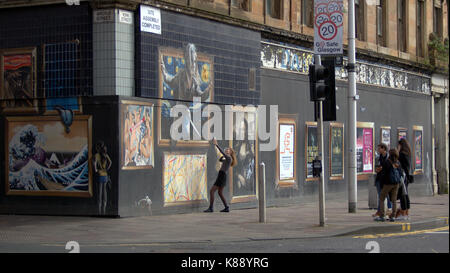 Touristen spielen und nehmen selfies auf der Vorderseite der Straße Wandmalereien zieren das Gebäude om Argyle Street Glasgow Stockfoto