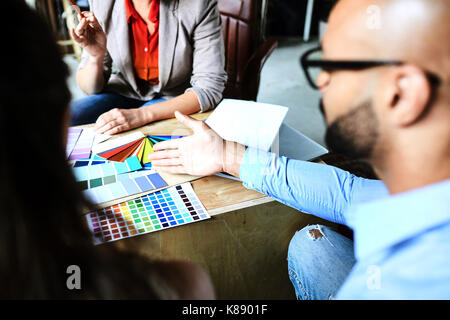 Einer der Designer auf eine Vielfalt von Farben in der Palette während Besprechungen mit Kollegen Stockfoto