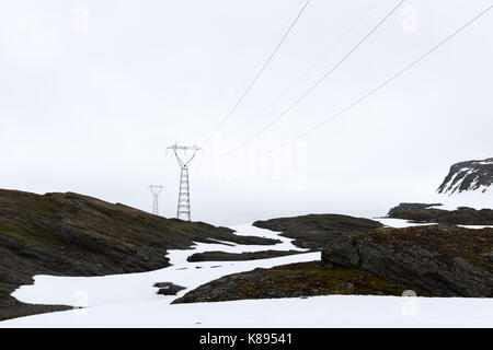 Typisch norwegische Landschaft mit schneebedeckten Bergen und elektrische Leitung in der Nähe des berühmten Aurlandsvegen (Bjorgavegen), Mountain Road, Aurland, Norwegen. Stockfoto