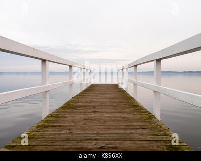 Bad Zwischenahn, Deutschland - 23 November, 2016: White Wooden Boat Dock am See bei Sonnenuntergang Stockfoto