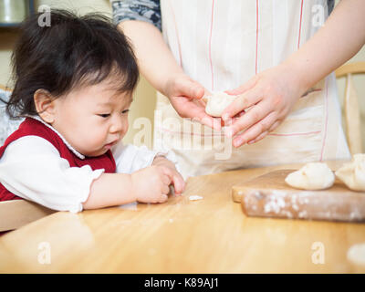 Adorable Baby Girl, Gyoza mit Mom Stockfoto