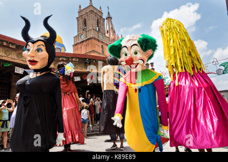 Riesige Papierpuppen, Mojigangas genannt, tanzen vor der Kirche Parroquia de San Miguel Arcangel während einer Kinderparade, die den mexikanischen Unabhängigkeitstag feiert 17. September 2017 mâché San Miguel de Allende, Mexiko. Stockfoto