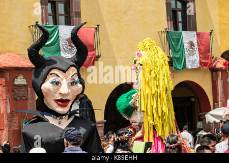 Riesige Pappmaché-Puppen namens Mojigangas tanzen im Jardin Allende während einer Kinderparade, die die Feierlichkeiten zum mexikanischen Unabhängigkeitstag am 17. September 2017 in San Miguel de Allende, Mexiko, feiert. Stockfoto