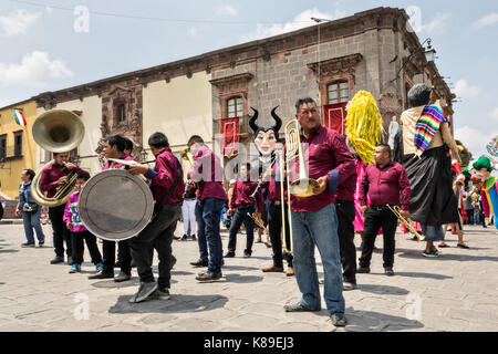 Eine Blaskapelle führt eine Prozession von riesigen Pappmaché-Puppen namens Mojigangas im Jardin Allende während einer Kinderparade, die den mexikanischen Unabhängigkeitstag feiert 17. September 2017 in San Miguel de Allende, Mexiko. Stockfoto