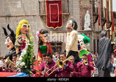 Eine Blaskapelle führt eine Prozession von riesigen Pappmaché-Puppen namens Mojigangas im Jardin Allende während einer Kinderparade, die den mexikanischen Unabhängigkeitstag feiert 17. September 2017 in San Miguel de Allende, Mexiko. Stockfoto