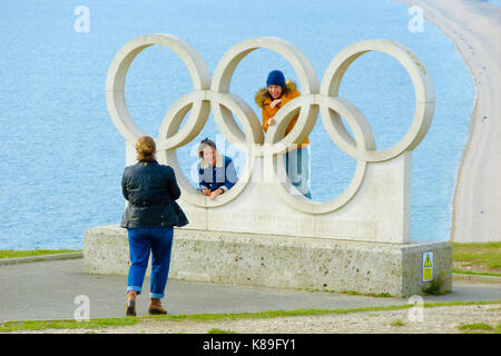 Isle of Portland, Großbritannien. 18 Sep, 2017. Junge Frauen posieren für Fotos in der 2012 Olympischen Ringe mit Blick auf Chesil Beach, an der Portland Höhen Credit: stuart Hartmut Ost/Alamy leben Nachrichten Stockfoto