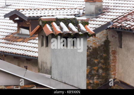 Fliesen und einen konkreten Schornstein mit Schnee Stockfoto