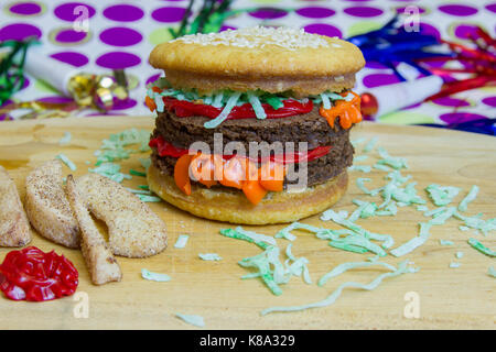 Dessert Hochstapler mock double Cheeseburger mit Vanilla Cupcake bun- und brownie Burger auf Holz Schneidebrett mit mock apple Pommes und Ketchup. Stockfoto