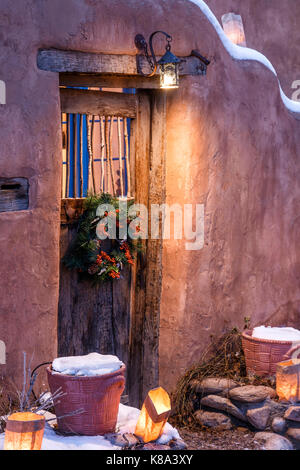 Tür mit Weihnachten Kranz und Farolitos, Farolito gehen, Canyon Road, Santa Fe, New Mexico USA Stockfoto