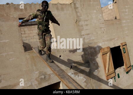 Ein Legionär aus dem 2 REP (2. Ausländische Paratroop Regiment) nach unten läuft ein Brett von einem geöffneten Fenster während einer städtischen bekämpfen Übung in Fraseli, Korsika Stockfoto