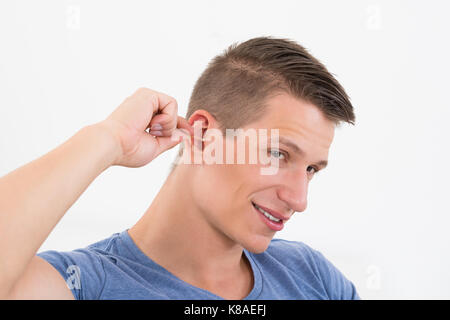 Close-up des jungen Mannes Reinigung sein Ohr Stockfoto