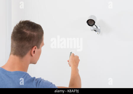Close-up des jungen Mannes, die Sicherheit des Betriebs Kamera mit Fernbedienung Stockfoto