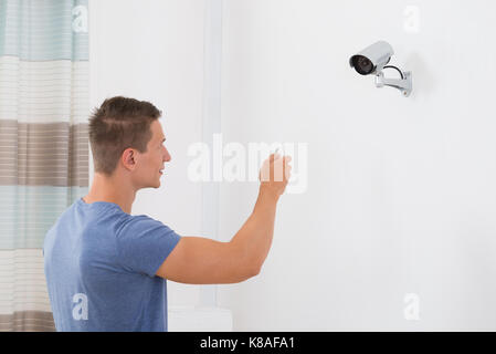 Close-up des jungen Mannes, die Sicherheit des Betriebs Kamera mit Fernbedienung Stockfoto