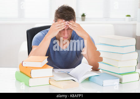 Portrait von Müde junge Menschen studieren Bücher am Schreibtisch Stockfoto